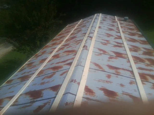 Rusted metal roof panels with new wood purlins before replacement — Storm Damage Roof Repair in May by Roofing Brothers